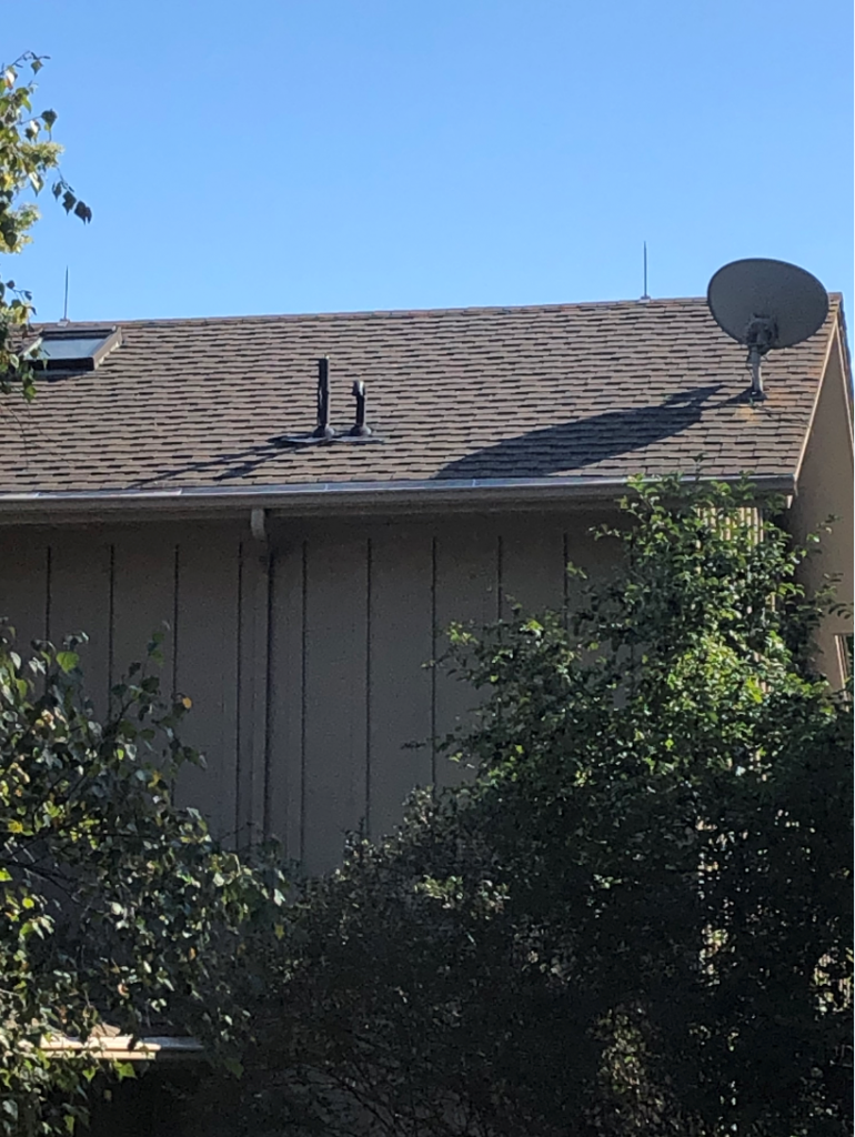 Residential home exterior with roof and satellite dish, illustrating house cleaning services.